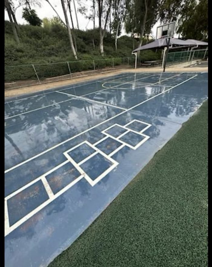 Wet outdoor basketball/multi-use court after cleaning